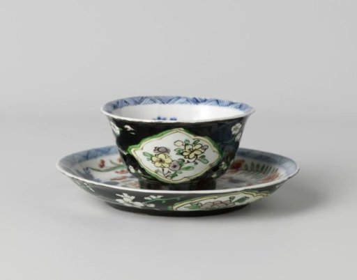 Cup and saucer with flower sprays in panels on a black ground