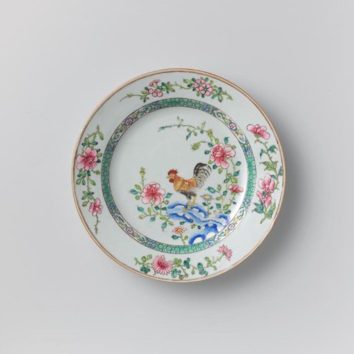 Plate with a cock on a rock near flowering plants