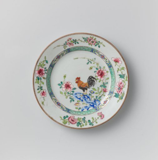 Plate with a cock on a rock near flowering plants
