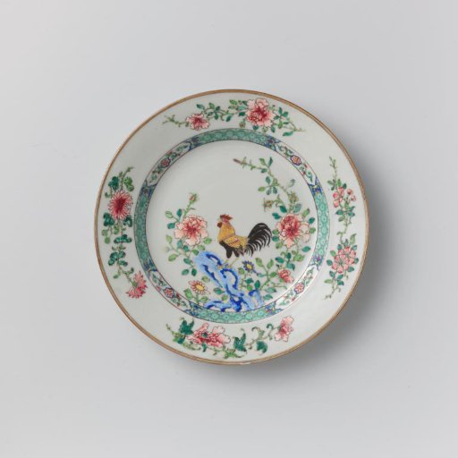 Plate with a cock on a rock near flowering plants