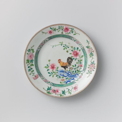 Plate with a cock on a rock near flowering plants