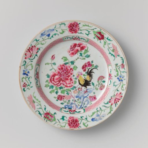 Plate with a cock on a rock near flowering plants