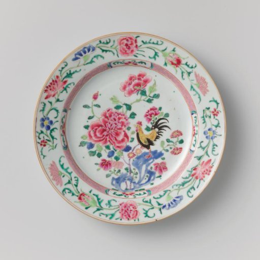 Plate with a cock on a rock near flowering plants