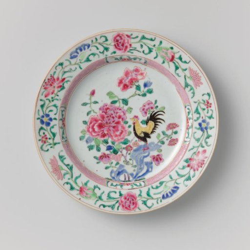 Plate with a cock on a rock near flowering plants