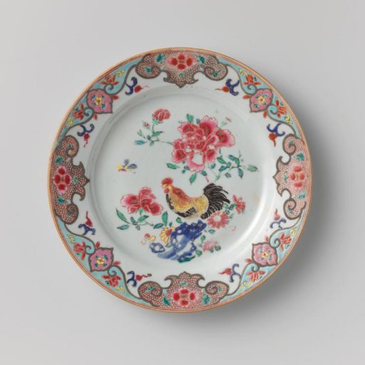 Plate with a cock on a rock near flowering plants