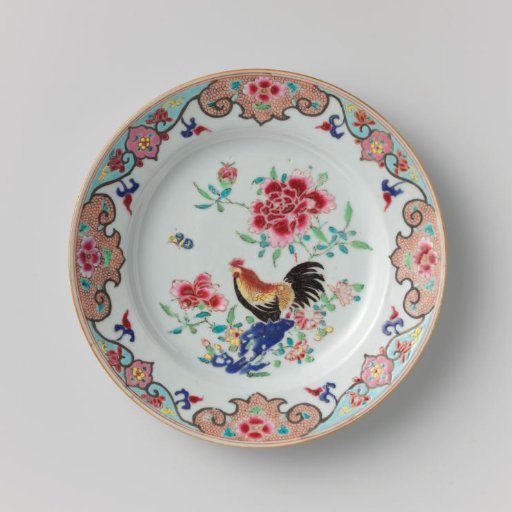 Plate with a cock on a rock near flowering plants