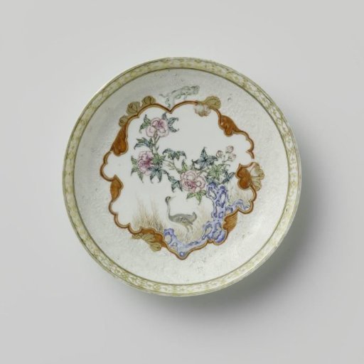 Saucer with a crane near a peony plant and rock