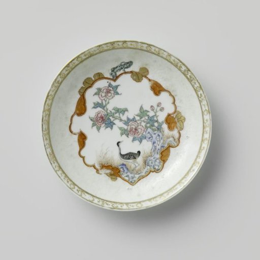 Saucer with a crane near a peony plant and rock