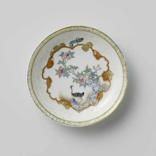 Saucer with a crane near a peony plant and rock