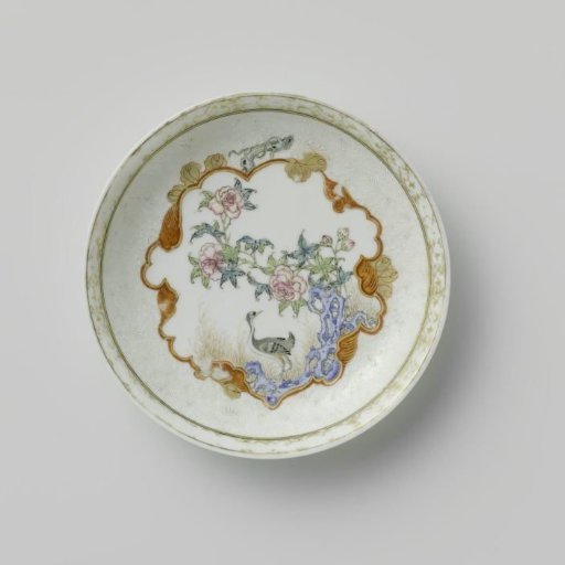 Saucer with a crane near a peony plant and rock