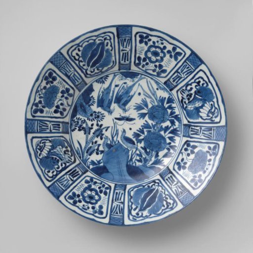 Dish with birds and a butterfly near rocks and flowering plants