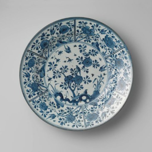 Dish with birds and insects near flowering plants and a rock