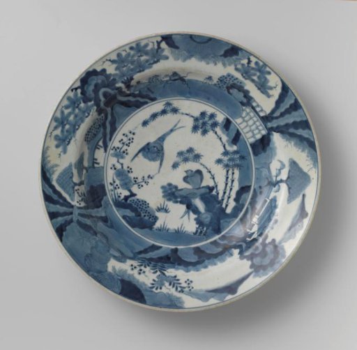 Dish with two birds near rocks and flowering plants