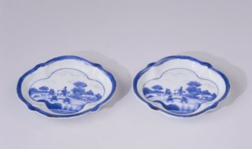 Saucer with figures on a bridge in a water landscape with trees and houses