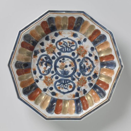 Dish with fluted sides and flowering plants near a fence and floral scrolls