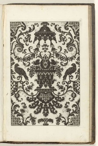 Pattern in black on a white ground. On a pedestal is a vase with bunches of grapes...