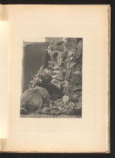 Woman seated behind a table with food and dried flowers