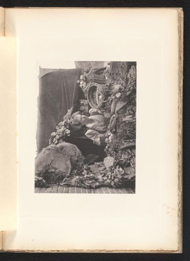Woman seated behind a table with food and dried flowers