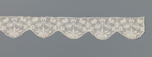 Strip of bobbin lace with a palm flower in shells