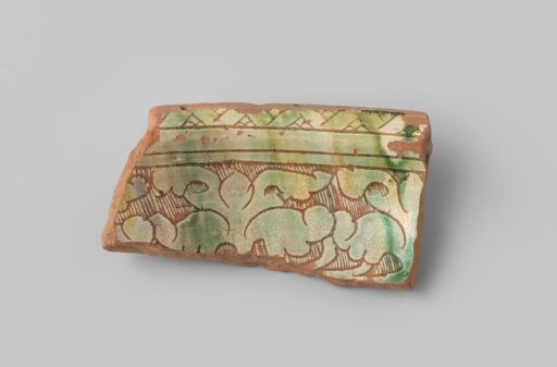 Fragment of a plate with a red-firing sherd, featuring stripes and floral forms on the front in sgraffito technique with white, yellow, and green glaze