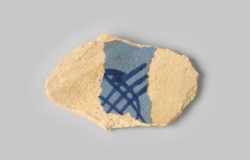 Fragment of a plate with a yellow-firing sherd, with remnants of light blue glaze on the front and back, decorated with dark blue glaze