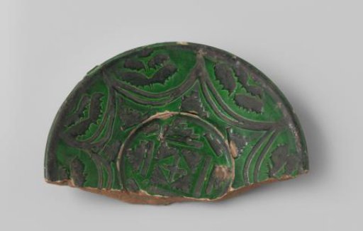 Fragment of a plate with a red-fired sherd, glazed in green, with incised geometric patterns in black glaze