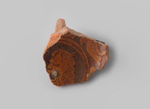 Fragment (foot) with red sherd, in sgraffito drawing within a circle a lion's head, bottom and top glazed brown