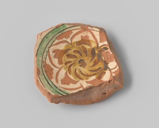 Fragment (foot) with red sherd, with a flower in sgraffito technique in white, ochre, and green on the upper side