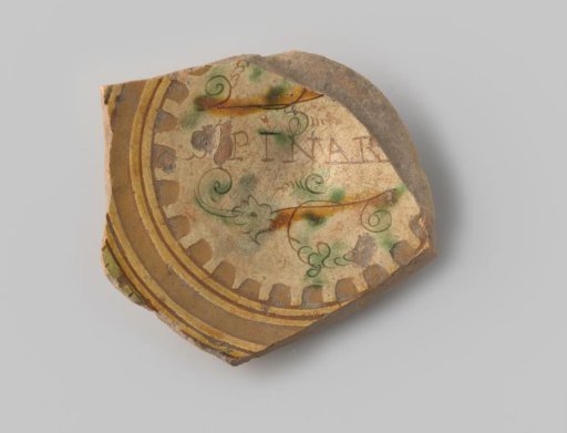Fragment (foot) with red sherd; in sgraffito technique within brown and ochre circles, several fleetly scratched vines, decorated with touches of green and ochre, between which the letters SPINAR appear