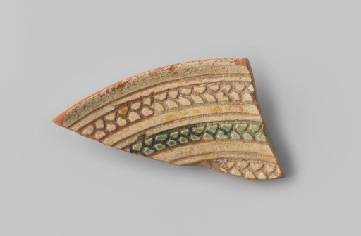 Fragment (voet) met rode scherf, aan de binnenkant in sgraffito-techniek lijnen waarvan drie opgedeeld in vakken