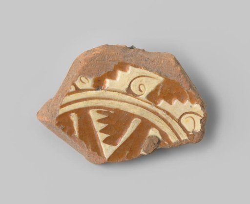 Fragment of red-fired earthenware, with a geometric relief pattern and white glaze on the upper side, with colorless and white glaze on the underside
