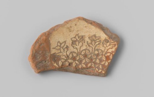 Fragment with a red sherd, provided at the top with floral decoration in sgraffito technique with white glaze