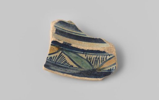 Fragment (foot) with a yellowish sherd, with bands, stripes and planes in blue and yellow on a white background on the upper side