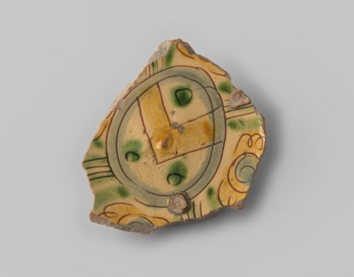 Fragment (foot) with red sherd, in sgraffito technique an egg-shaped coat of arms with a band and three roundels, in green and ochre, in a pale blue border