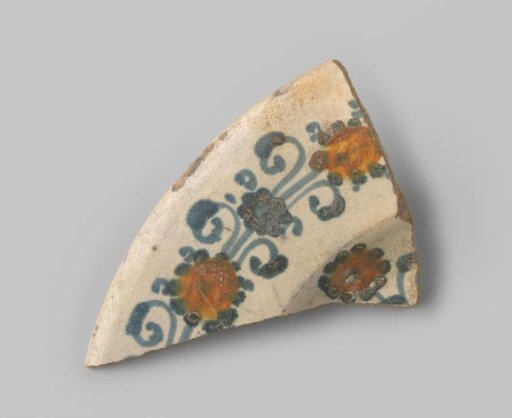Sherd of white-firing earthenware, decorated on the front with a floral design in blue and yellow on white glaze, white glaze on the back