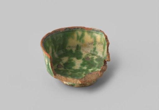 Fragment of a foot and rim of a small bowl with red sherd, white glaze, green spotted