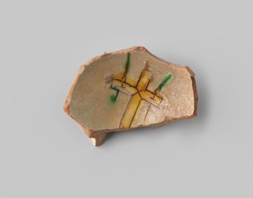 Fragment (foot) with red sherd; in sgraffito technique, a cross in ochre in the center, with vertical arrows (nails?) with green points in the side arms, on a beige ground