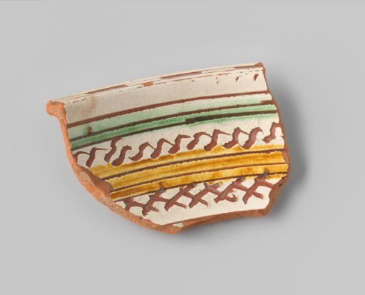 Fragment with red sherd, decorated on the front with floral forms and bands in sgraffito technique with ochre and green glaze on a white background