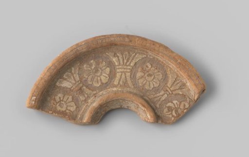 Fragment with red sherd, on the upper side provided with flowers and columns in sgraffito technique in white glaze
