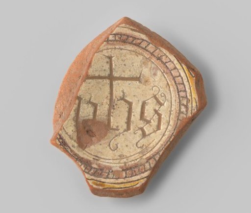 Fragment (foot) with red sherd; in sgraffito technique within several circles (ochre and manganese purple), something resembling IIHS painted in elegant letters