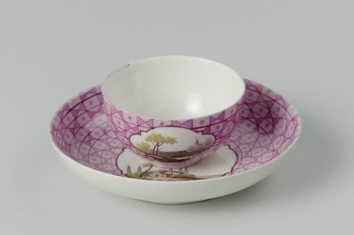 Cup and saucer with a multicoloured landscape in a medallion cut out in a geometric pattern
