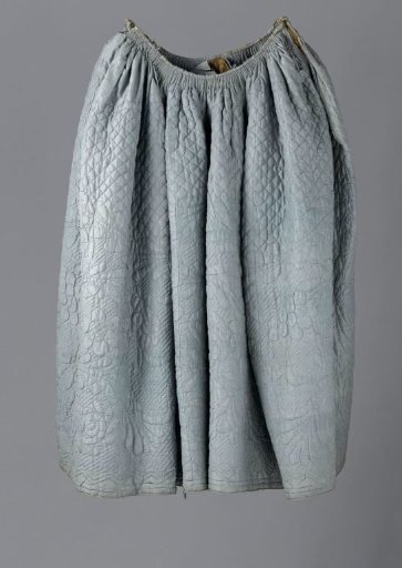 Skirt with side slits and brown linen lining of blue, quilted and stitched silk, from above with a diamond pattern and from below with large flower and leaf motifs.