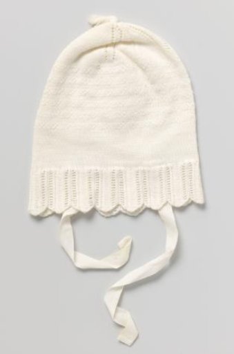 Children's sleeping cap of knitted white cotton, with a wide scalloped edge with openwork and on top with openwork edges and a tassel; marked in red cross-stitch: H8