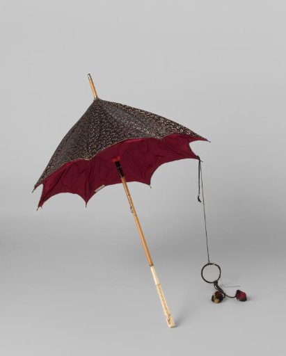 Parasol with canopy of black silk with a scattered motif of white botanicals and red stripes, lined with dark red silk, on a thin bamboo shaft with a carved ivory handle and metal tip