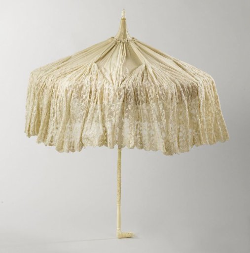 Parasol with canopy of champagne-coloured silk and machine embroidery on tulle hanging all around, shaft of white painted maple wood, handle of ivory in the shape of a recumbent dog