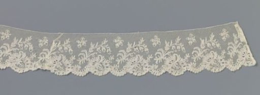 Strip of bobbin lace with an oblique flower under an oblique branch