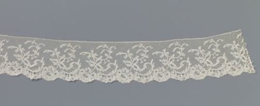 Strip of bobbin lace with hanging flower and comma-shaped motif