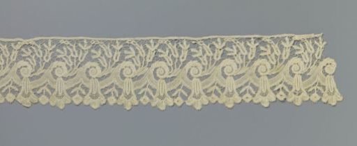 Strip of bobbin lace with cup-shaped flower under an overhanging wave