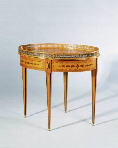 Tea table, decorated with marquetry of satinwood, rosewood, violetwood and mahogany on an oak core. Oval top with raised openwork rim and square tapering legs on brass cap feet