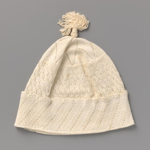 Knitted nightcap of white cotton with a turned-over scalloped edge with diagonally knitted stripes, above which a decorative pattern; on top star-shaped with openwork edges